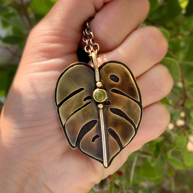 Monstera leaf necklace with peridot in brass