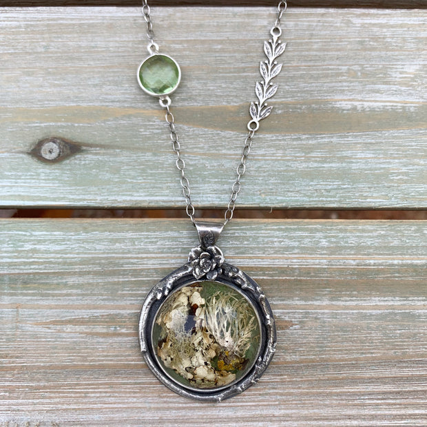 Silver nature necklace with lichen terrarium, green amethyst, silver vines, succulent, and twig